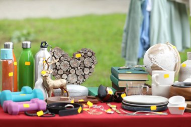 Different items on table outdoors. Garage sale