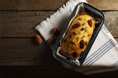 Delicious pumpkin bread with pecan nuts on wooden table, flat lay. Space for text