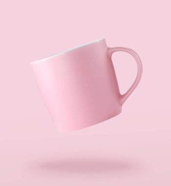 One empty ceramic cup falling on pale pink background