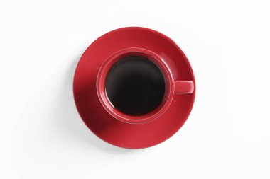 Red cup with aromatic coffee on white background, top view
