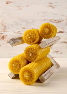 Stylish elegant beeswax candles on white wooden table