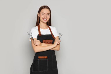 Profesyonel makasıyla arka planda mutlu bir kuaför portresi. Metin için boşluk