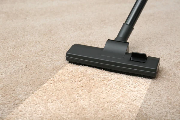 Vacuuming dirty beige carpet. Clean area after using device, closeup