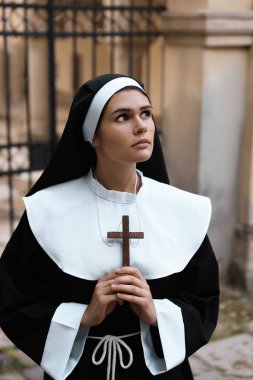 Hristiyan haçı olan genç rahibe bina yakınlarında.
