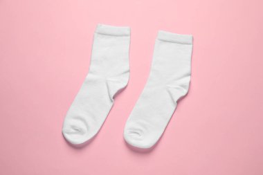 Pair of white socks on pink background, flat lay
