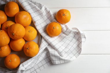Many fresh ripe tangerines on white wooden table, flat lay. Space for text