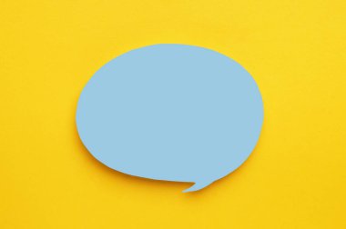 Sarı arka planda kağıt konuşma balonu, üst manzara. Metin için boşluk