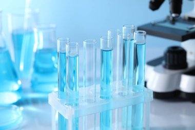Laboratuvarda açık mavi sıvıyla test tüpleri, yakın plan.