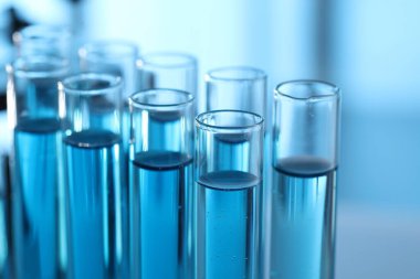 Laboratuvarda açık mavi sıvıyla test tüpleri, yakın plan.