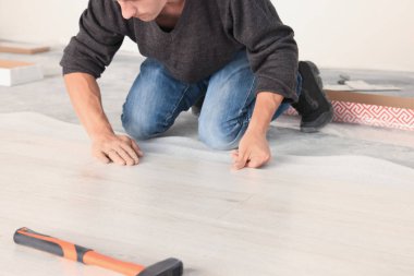 Profesyonel işçi, yeni kaplama döşemeleri yerleştiriyor.