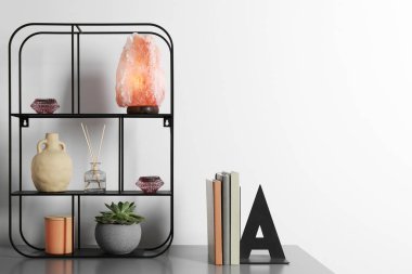 Dekoratif unsurları olan raf ünitesi ve çekmeceler üzerine kitaplar, yazı için yer. İç tasarım