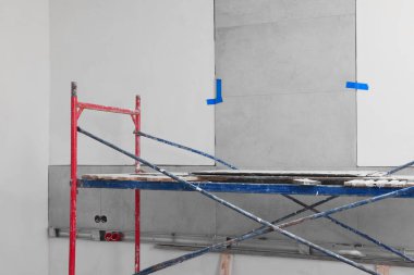 Tower tour near wall with adhesive mix and tiles indoors