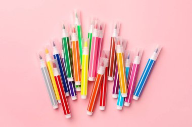Many bright markers on pink background, flat lay