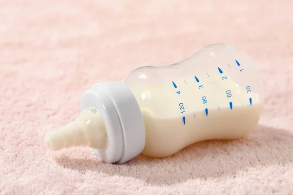 Feeding bottle with baby formula on soft towel