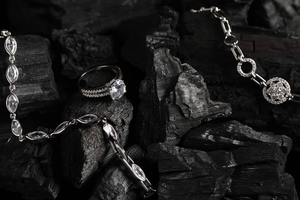 Luxury jewelry. Stylish presentation of elegant ring and bracelets on coal