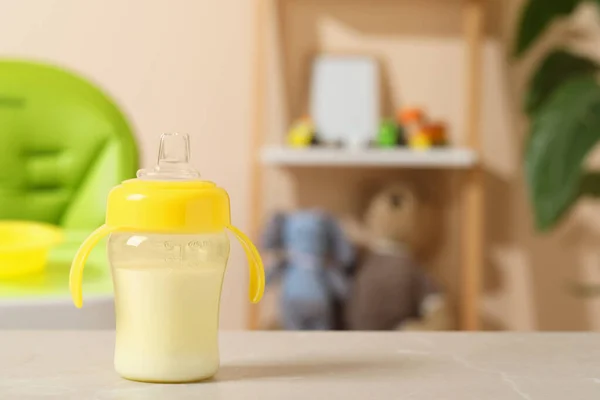 Feeding bottle with baby formula on light grey table indoors. Space for text