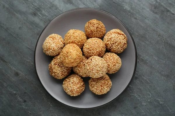 Delicious sesame balls on grey table, top view