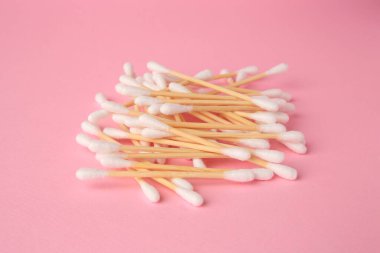 Heap of clean cotton buds on pink background