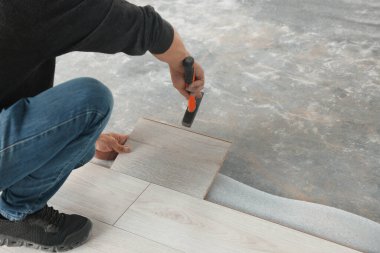 İşçi odaya yeni kaplama döşemeler kuruyor, kapatıyor