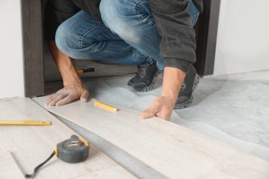 İşçi odaya yeni kaplama döşemeler kuruyor, kapatıyor