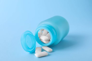 Açık mavi arka planda lezzetli diş etleri olan kavanoz.