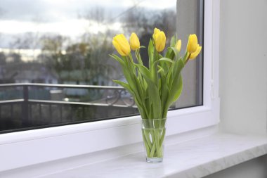 Wonderful tulips on window sill indoors, space for text. Spring atmosphere