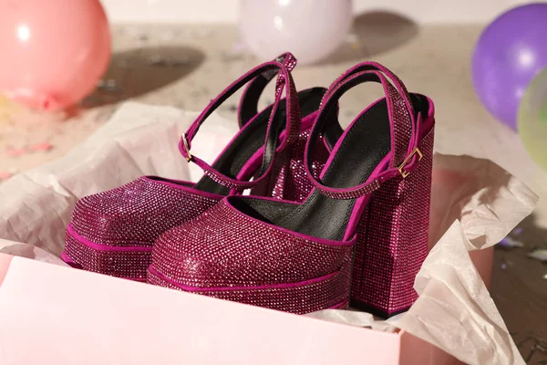 Stylish party. New pink high heeled shoes with platform and square toes in open box on floor, closeup