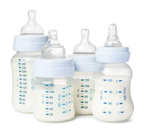 Many feeding bottles with infant formula on white background