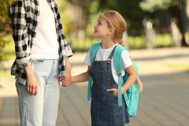 Little girl with her mother on way to school