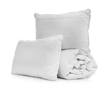 Beyaz arka planda yastıkları olan yumuşak bir battaniye.