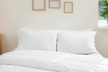 White soft pillows on cozy bed in room