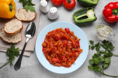 Delicious lecho and ingredients on light gray table, flat lay