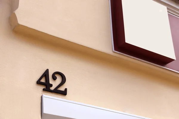 House number 42 on beige wall outdoors