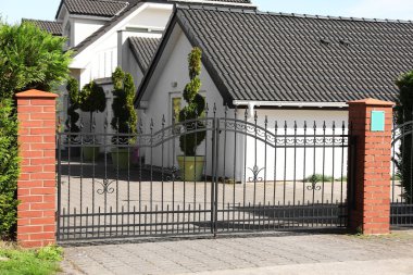 Metal gates near beautiful houses on sunny day