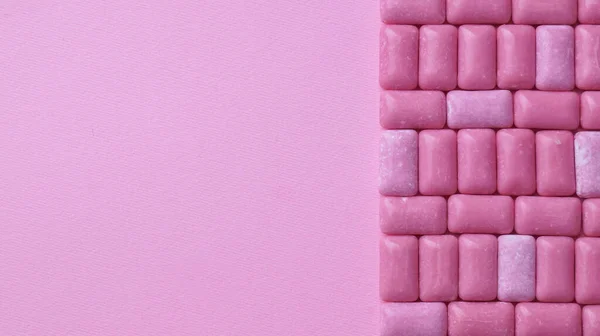 Many sweet chewing gums on pink background, flat lay. Space for text