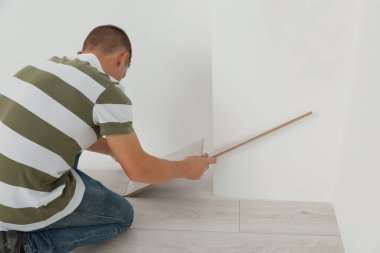 Profesyonel işçi, yeni kaplama döşemeleri yerleştiriyor.