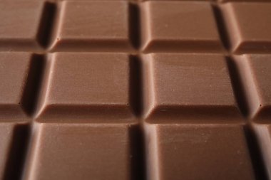 Delicious milk chocolate bar as background, closeup