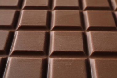 Delicious milk chocolate bar as background, closeup