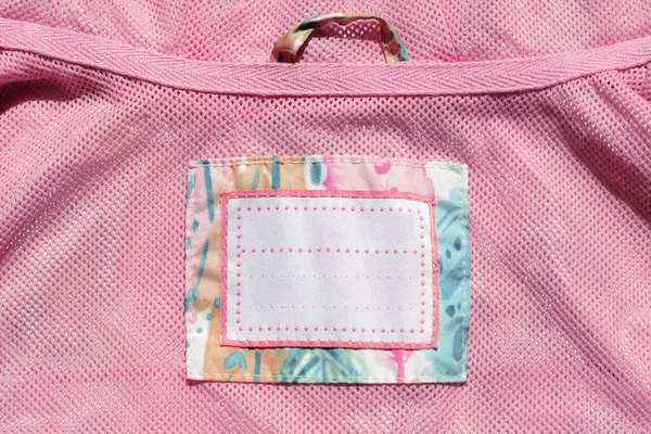 Clothing label on pink garment, top view