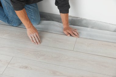 İşçi odaya yeni kaplama döşemeler kuruyor, kapatıyor