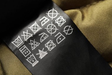 Clothing label on beautiful garment, closeup view