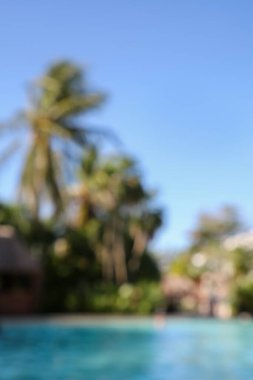 Güneşli bir günde tatil köyündeki açık yüzme havuzunun bulanık manzarası