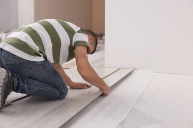 Profesyonel işçi, yeni kaplama döşemeleri yerleştiriyor.