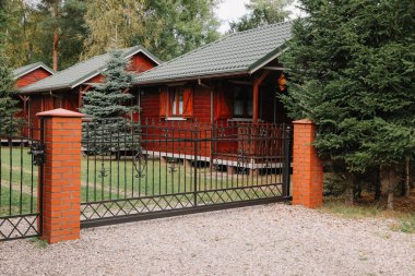 Closed metal gates near beautiful garden and houses outdoors