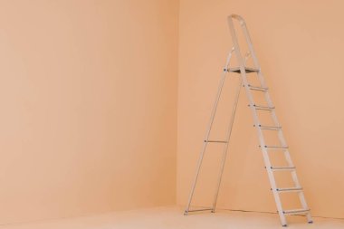 Soluk turuncu duvarın yanındaki merdiven, yazı için yer. Oda yenileme