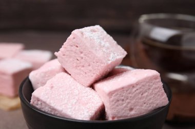 Bowl of delicious sweet marshmallows with powdered sugar, closeup