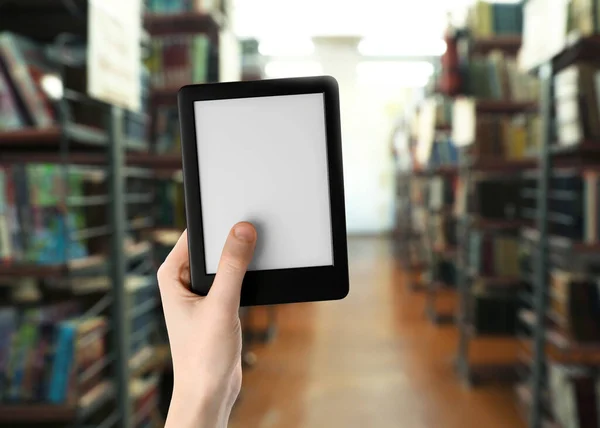 Woman holding e-book reader in library, closeup