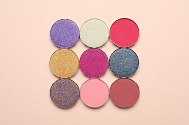Beautiful eye shadow refill pans on beige background, flat lay