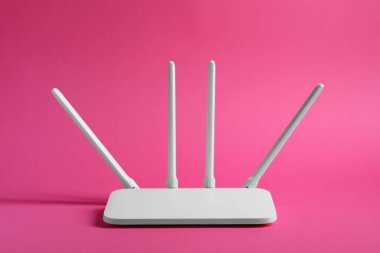 New white Wi-Fi router on pink background