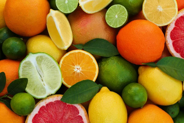 新鮮な柑橘類や葉を背景に トップビュー — ストック写真